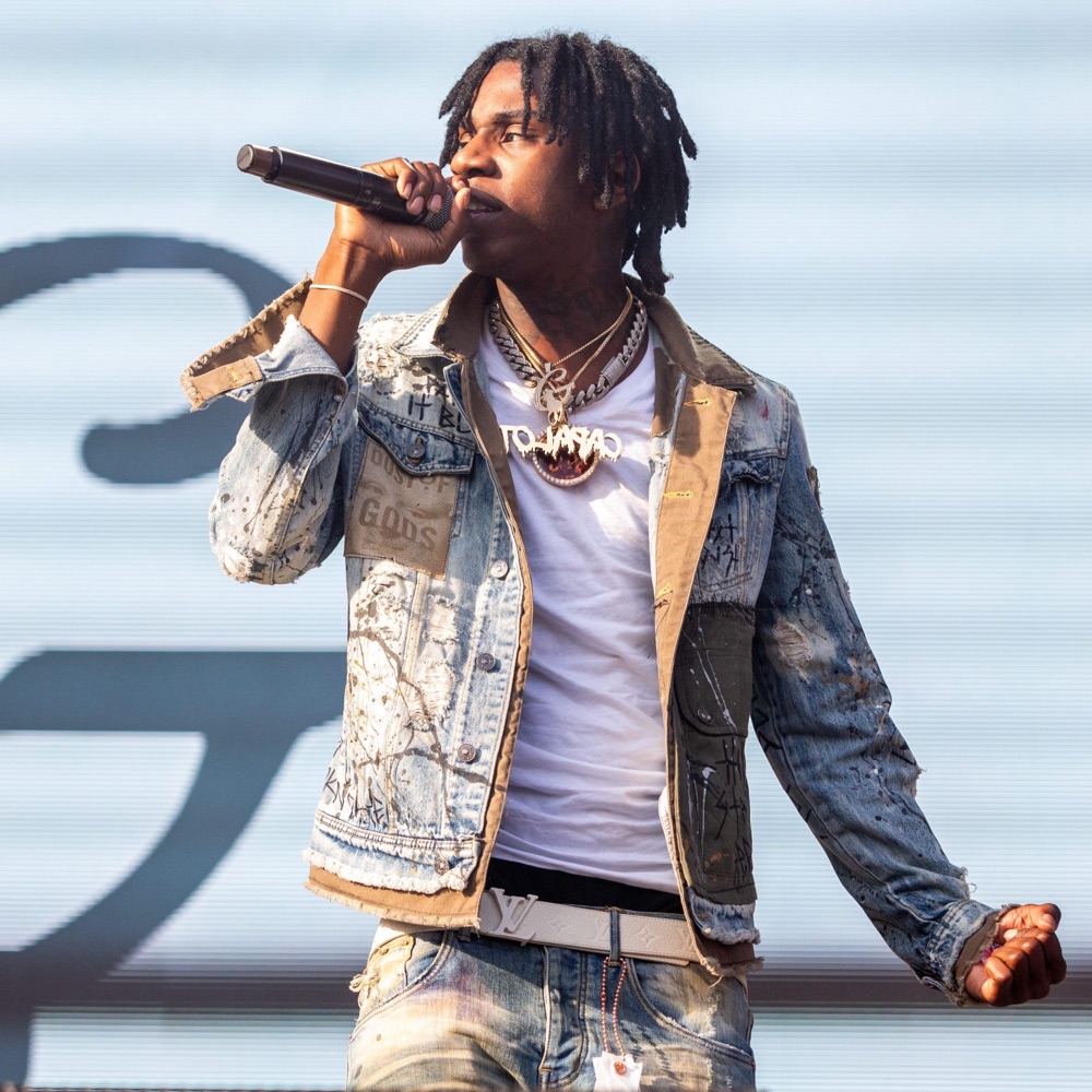 Polo G performing on stage with a microphone